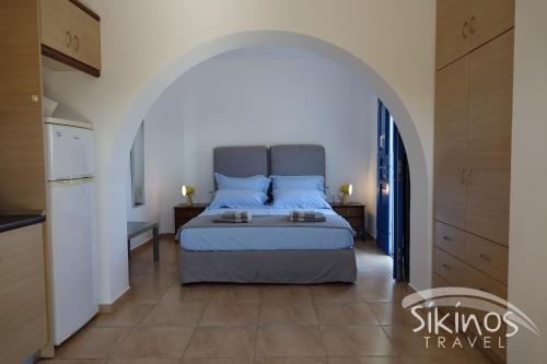 a bedroom with a large bed in an archway at Sikinos Elegant Studio in Síkinos
