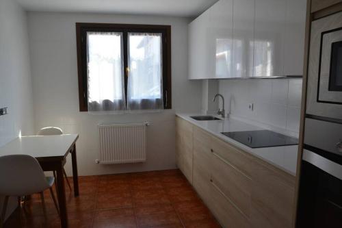 a kitchen with a sink and a table and a window at Casa Miruetxe in Lekunberri
