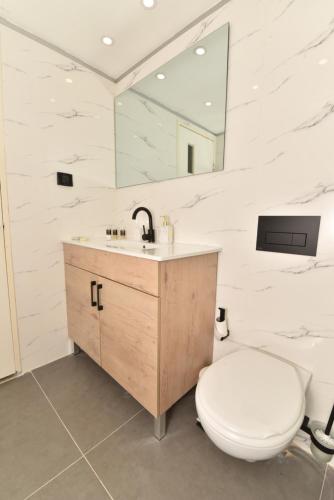 bagno con servizi igienici, lavandino e specchio di Royal Park Eilat - Garden Apartment by CROWN a Eilat