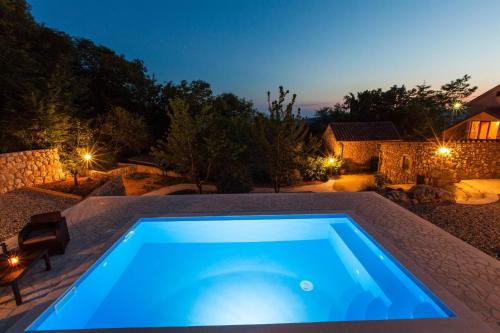 uma piscina no quintal de uma casa à noite em KUCA MARSSILI em Grižane