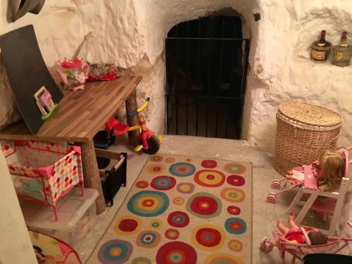 a little girl sitting on a chair in a play house at Casa Cueva ARACELI in Alcalá del Júcar