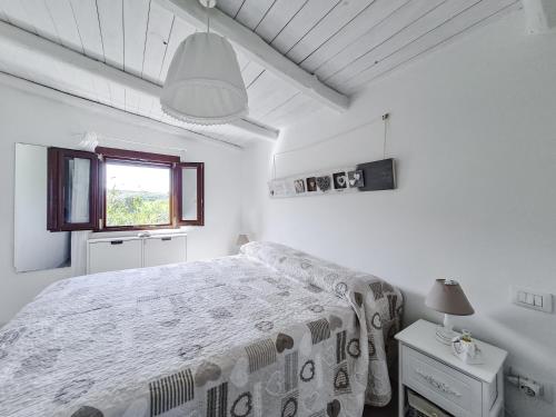 カステルサルドにあるAppartamento La Palmaの白いベッドルーム(ベッド1台、窓付)