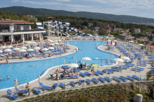a large swimming pool with chairs and people in it at Nevis Resort & Aqua Park - All Inclusive in Sunny Beach
