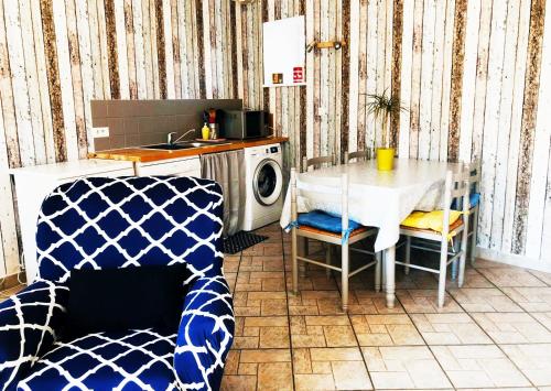 a kitchen with a table and a washing machine at Maison de La Beslière meublé de tourisme 2 étoiles in Folligny
