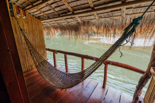a hammock on a boat with a view of the water at River Kwai Jungle Rafts in Sai Yok