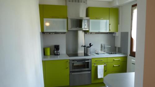 - une cuisine avec des armoires vert citron et un évier dans l'établissement La Maison Cent 5 avec parking privé, à Saint-Valery-sur-Somme