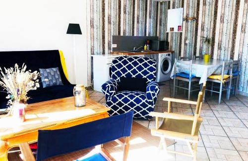 uma sala de estar com um sofá e uma mesa em Maison de La Beslière meublé de tourisme 2 étoiles em Folligny