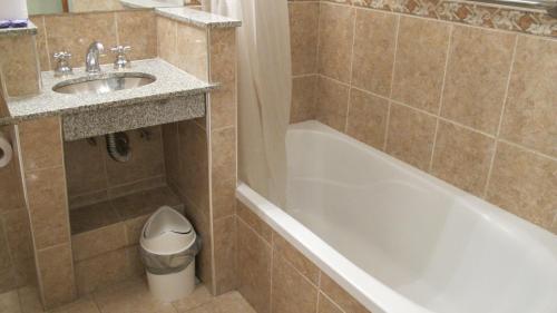 a bathroom with a sink and a bath tub and a sink at Hotel Pedraza in Buenos Aires