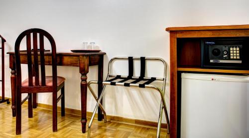 a kitchen with a table and a microwave and a chair at Villa Fortuna in Mostar