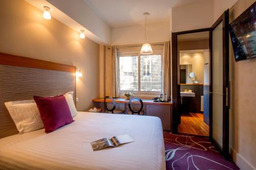 Hôtel de Normandie في بوردو: غرفة في الفندق مع سرير مع طبق من الطعام عليه