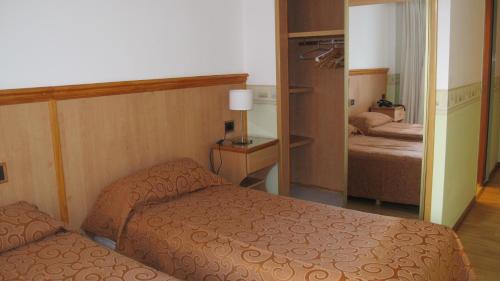 a small bedroom with two beds and a mirror at Hotel Pedraza in Buenos Aires