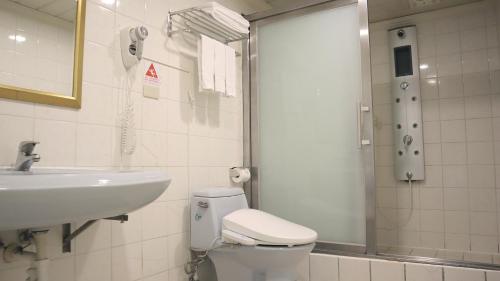 a bathroom with a toilet and a sink and a shower at Ho Fong Business Stay in Fengyuan