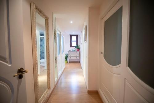 a hallway with a mirror and a white door at Arenda Villa Rosa in Hospitalet de l'Infant