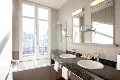 baño con 2 lavabos y espejo grande en Hôtel de Normandie, en Burdeos