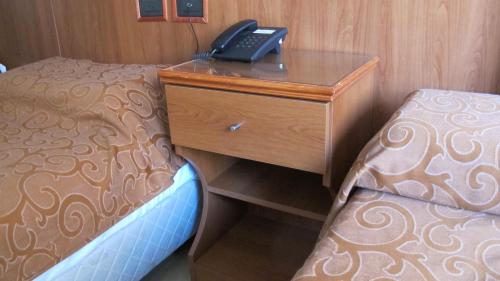 a bedroom with a desk and a phone on a bed at Hotel Pedraza in Buenos Aires