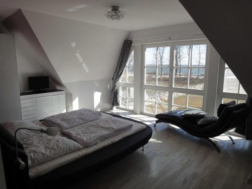 a bedroom with a bed and a large window at Ostsee Strandvilla Silvia in Lobbe
