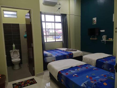 a room with three beds and a toilet and a window at VILLA SENTOSA in Kuala Terengganu