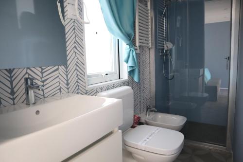 a bathroom with a sink and a toilet and a window at Ca' Pasquali Village in Cavallino-Treporti