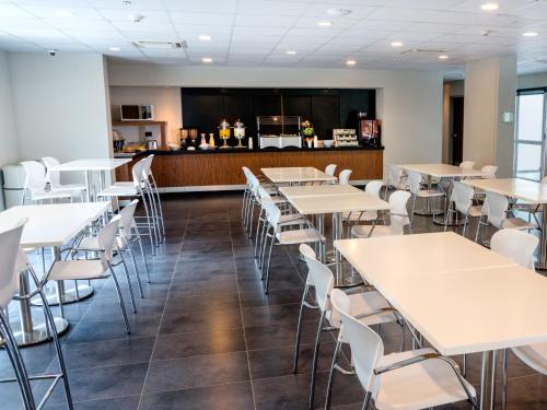 a dining room with tables and chairs and a bar at City Express Plus by Marriott Cali Colombia in Cali