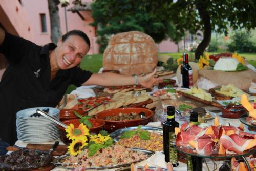 Un uomo seduto a un tavolo pieno di cibo di Tenuta La Tabaccaia a La Pesta