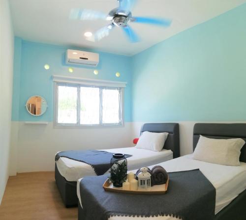 Habitación con 2 camas y ventilador de techo. en Klebang Seacove Villa by Nestcove en Melaka
