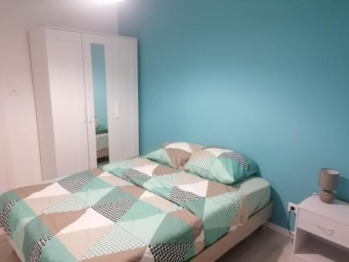 a bedroom with a bed and a blue wall at SWEET Appartment avec Wifi et parking in Clermont-Ferrand