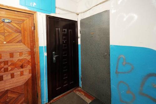 um pequeno quarto com uma porta preta e uma parede azul em Однокомнатная посуточно на Жукова 148Б em Omsk