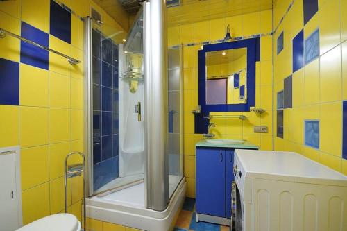 uma casa de banho com um chuveiro, um WC e um lavatório. em Однокомнатная посуточно на Жукова 148Б em Omsk