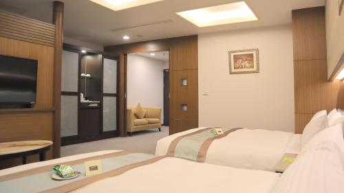 a hotel room with a bed and a television at Ho Fong Business Stay in Fengyuan