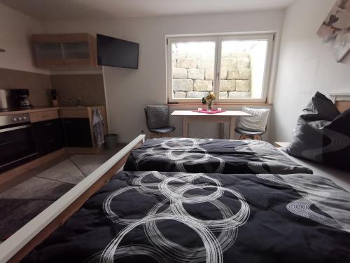 een slaapkamer met een bed, een tafel en een raam bij Kinderlachen in Wasserburg