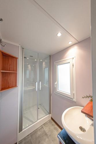 a bathroom with a glass shower and a sink at Albatross Mobile Homes on Camping Playa Brava in Pals