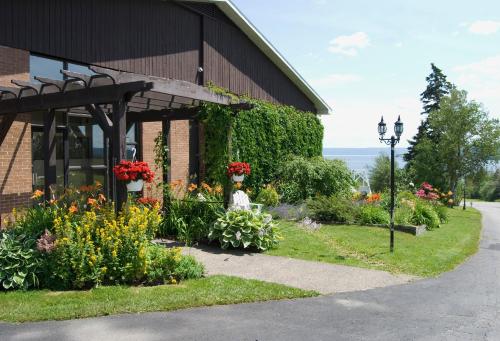 a garden outside of a building with flowers at Silver Dart Lodge in Baddeck