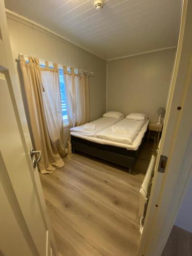 a small bedroom with a bed and a window at Mosjøen Overnatting, Vollanvegen 13 in Mosjøen