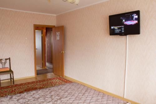 a room with a television on a wall with a bed at Ferrari Apartments in Vinnytsya