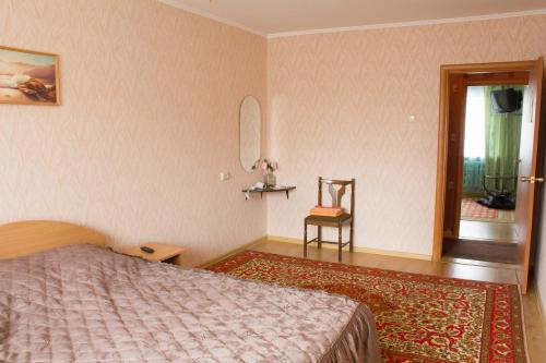 a bedroom with a bed and a chair and a window at Ferrari Apartments in Vinnytsya