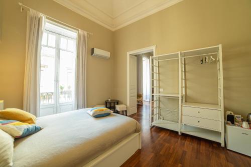 a bedroom with a bed and a large window at b&b le 4 leggende in Catania