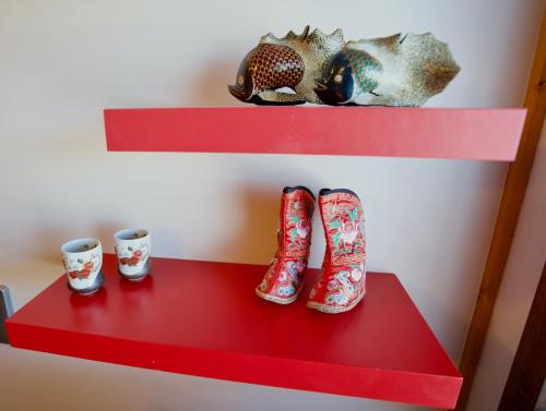 a shelf with red boots and two cups on it at Den Japanske Have B & B in Herning