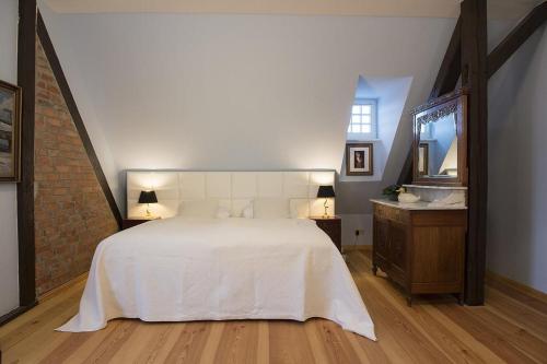 a bedroom with a large white bed and a mirror at Der Westflügel Admiralssuite WF-46 in Stolpe auf Usedom
