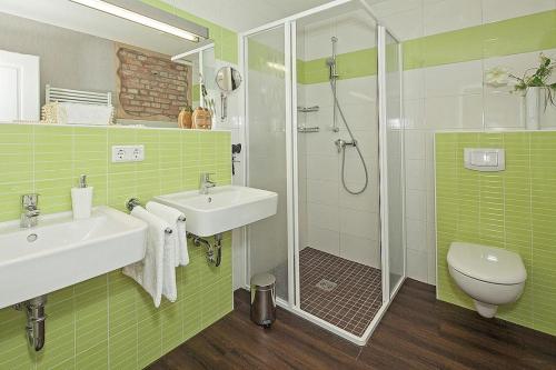 baño verde con 2 lavabos y ducha en Der Westflügel Ritter Dietrich WF-47, en Stolpe auf Usedom