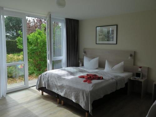 a bedroom with a bed with a red flower on it at Der Landhof Sanddorn in Stolpe