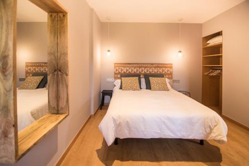a bedroom with two beds and a mirror at AGROTURISMO ZUMINTXAZ in Mungia