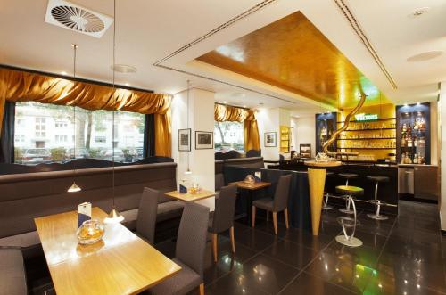 a restaurant with tables and chairs and a bar at Best Western Plus Arosa Hotel in Paderborn