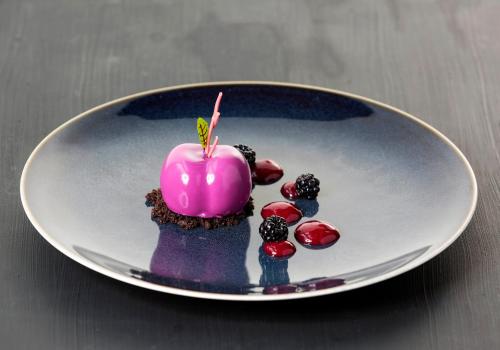 a pink candle on a plate on a table at The Gibson Hotel in Dublin