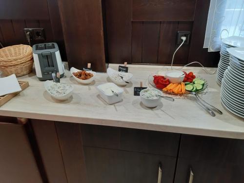 a counter with bowls of vegetables on a table at Hotel & Restaurant Hildebrandt in Breitenrode