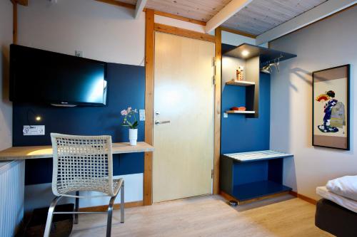 a room with a desk with a chair and a blue wall at Den Japanske Have B & B in Herning