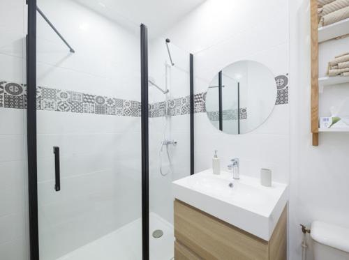 bagno con doccia, lavandino e specchio di T2 situé au cœur du centre historique de Dinan a Dinan