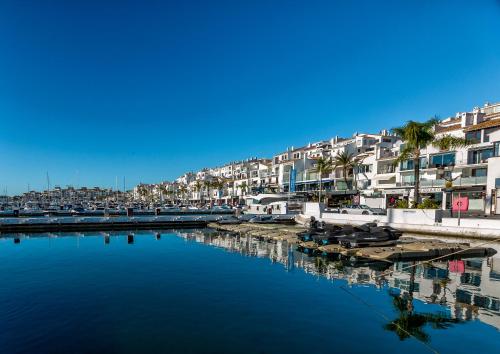 マルベーリャにあるFront Line Penthouse Puerto Banus With Sea Viewsの建物と水の港の景色