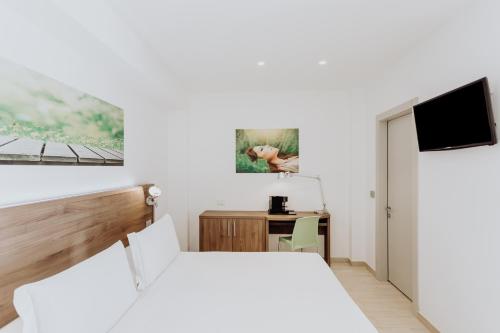 a bedroom with a bed and a desk and a tv at Privilege Apartments in Vimercate