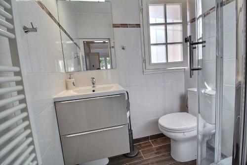 een witte badkamer met een toilet en een wastafel bij Le Petit Paradis - La Provençale in Lorgues