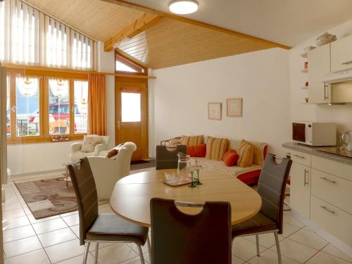 eine Küche und ein Wohnzimmer mit einem Tisch und einem Sofa in der Unterkunft Apartment Am Brienzersee by Interhome in Brienz